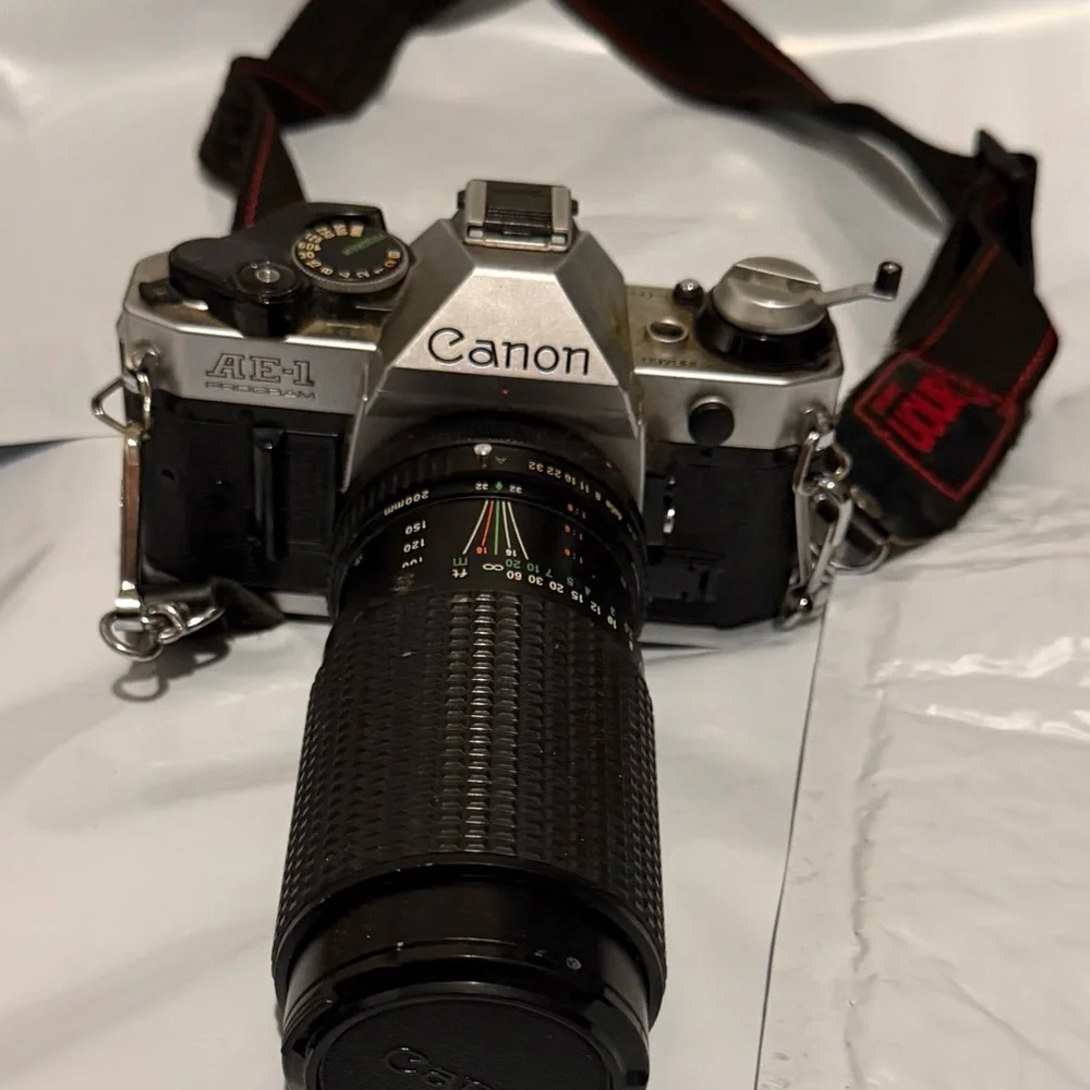 Canon silver and black SLR camera with black telephoto lens